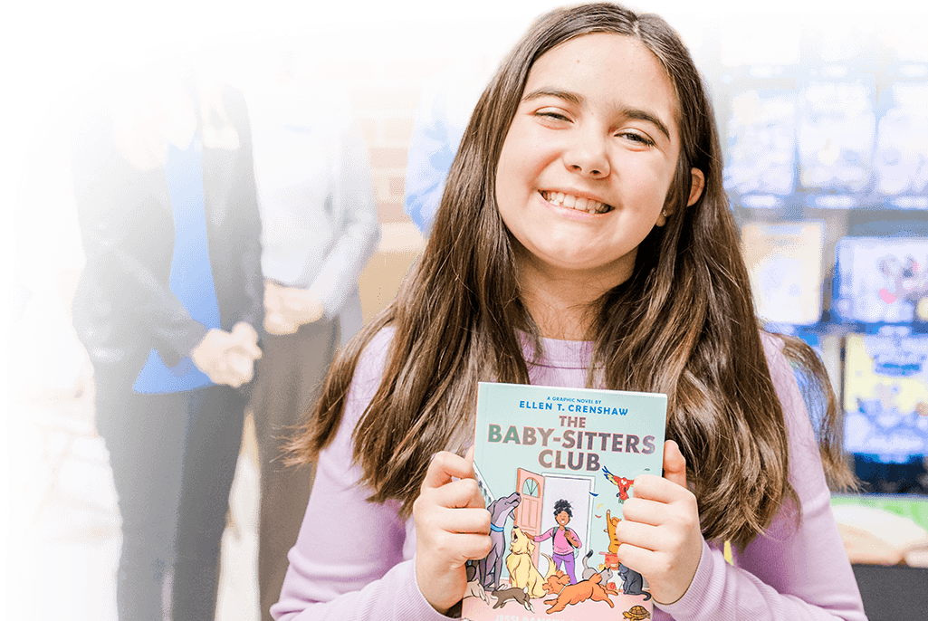 A student from Dranesville Elementary smiles with their donated book