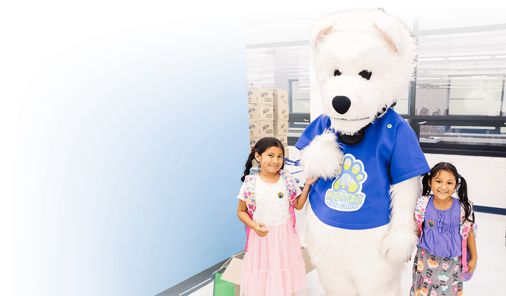 Dranesville students standing and smiling NWFCU Foundation bear mascot