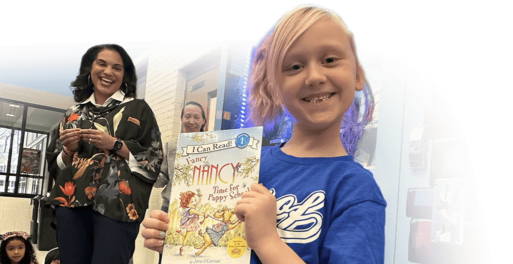 Child holding an open book during an educational foundation program activity