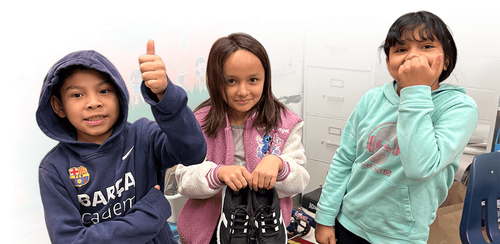 Kids with donated shoes from the Step Into Success program