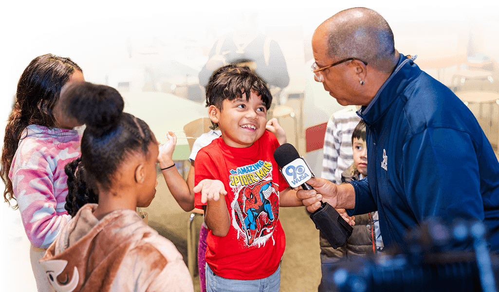 News interviewer speaking to a child with a microphone