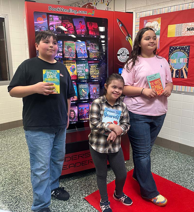 Sterling Middle School children holding books provided by the NWFCU Foundation
